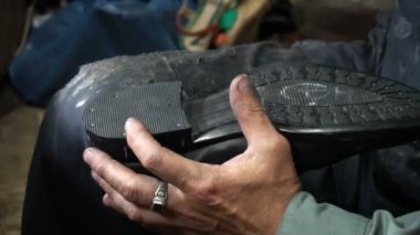 Shoemaker atölyede ayakkabıyı tamir ederken 4k topuk kapağını topuğa çiviler.
