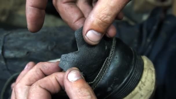 Il calzolaio attacca una toppa di pelle nera su scarpe da ginnastica — Video Stock