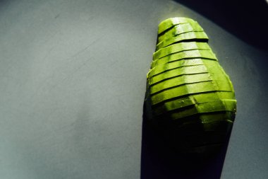 food background with fresh organic avocado on plate, top view, copy space