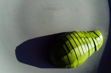 food background with fresh organic avocado on plate, top view, copy space