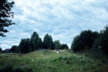 Bir kız yemyeşil bir tarlada koşuyor 