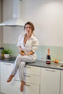 Beklerken bir fincan çayla mutfakta oturan kız.