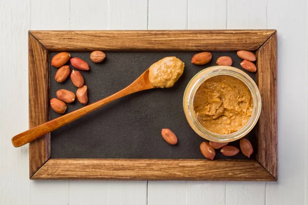 pot with peanut paste on a wooden table