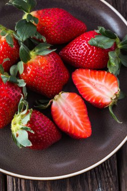 çilek kahverengi bir tabakta, ahşap masa