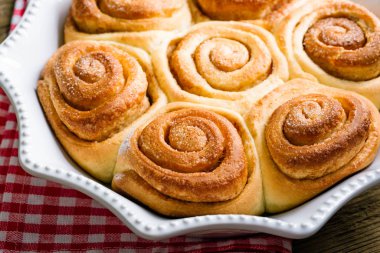 Tahta bir masada tatlı tarçınlı rulo, ev yapımı kekler.