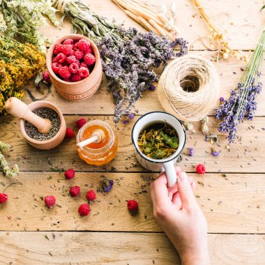 Tahta bir masada bitki çayı, bal ve ahududu, alternatif tıp, Ayurveda, kurumuş çiçekler.