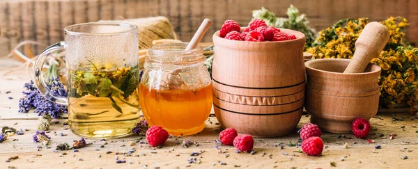 Tahta bir masada bitki çayı, bal ve ahududu, alternatif tıp, Ayurveda, kurumuş çiçekler. — Stok fotoğraf