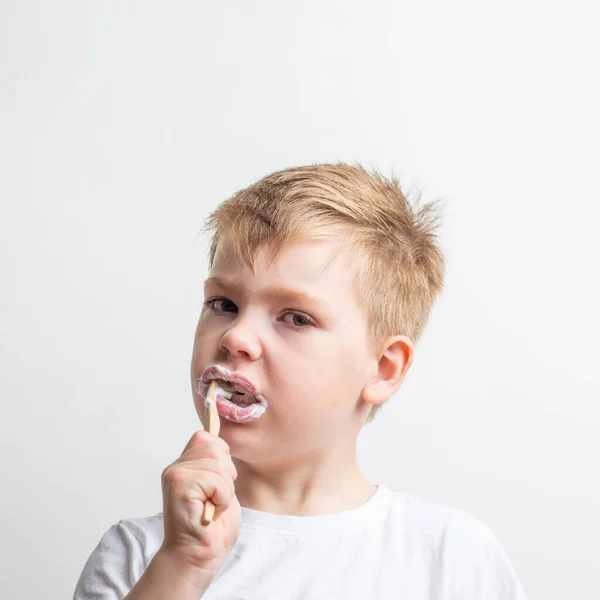 Cute boy posing with bamboo toothbrush in his mouth, child brushes his teeth — Stock Photo, Image