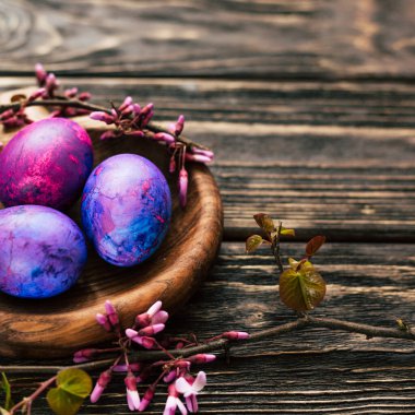 Yuvarlak tahta üzerinde leylak rengi paskalya yumurtaları