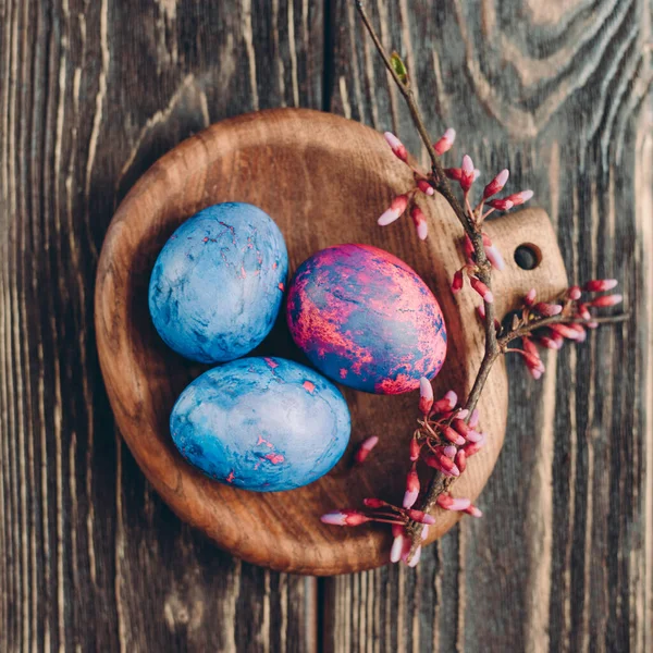 Ahşap arka planda pembe ve mavi paskalya yumurtaları