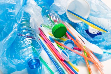 Beyaz arka planda mavi bir çantada plastik tabaklar.