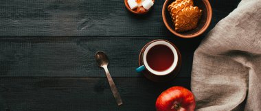 Siyah ahşap bir masada çay ve kurabiye, kopyalama alanı