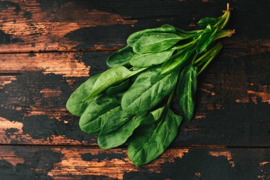 Koyu ahşap arka planda bir demet taze ıspanak