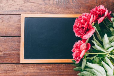 Tahta bir masada pembe şakayık demeti, kopyalama alanı.