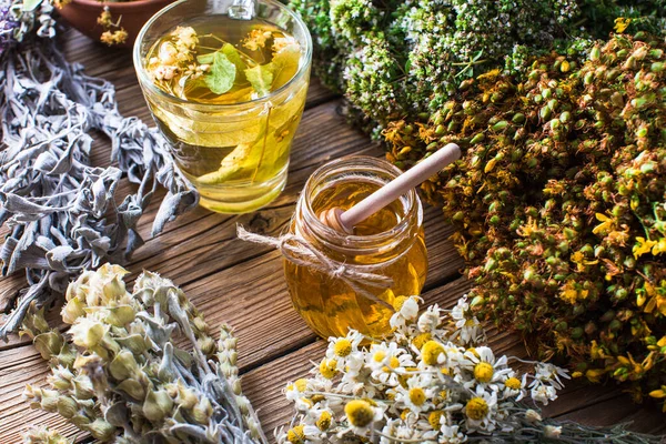 Harvesting healing herbs, linden flower tea and honey on a wooden background, alternative medicine