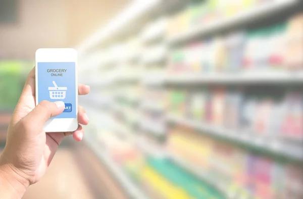 Mão segurando telefone inteligente com compras de supermercado on-line na tela — Fotografia de Stock