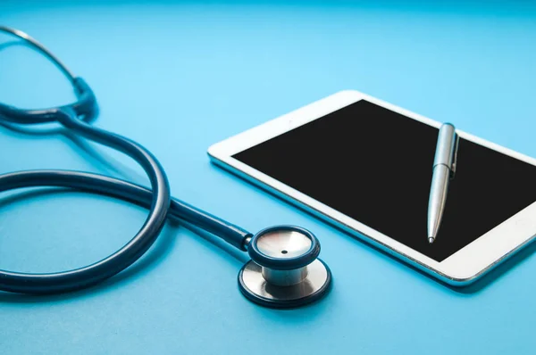Estetoscópio, tablet pc em fundo de cor azul. Técnico médico — Fotografia de Stock