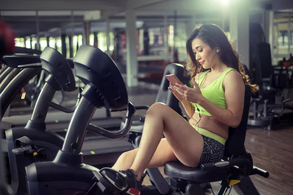 Sportif kadın smartphone cep telefonu ile spor salonunda müzik dinlemek