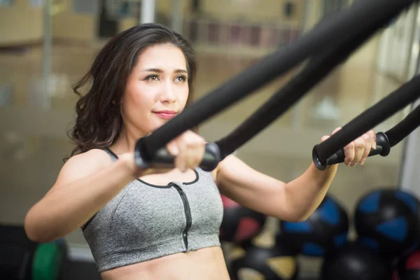 Femmes faisant push-ups bras d'entraînement avec des sangles de fitness trx dans le th Image En Vente