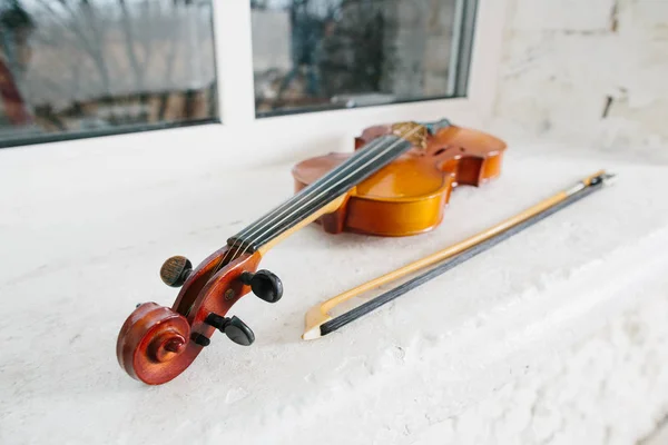 Violin and bow on window sill