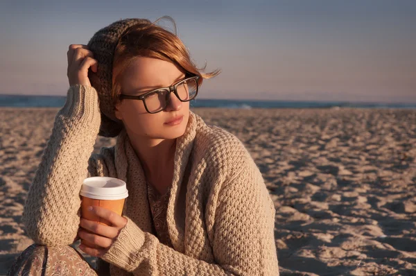 Kávét iszik a strandon őszén, a gyönyörű nő — Stock Fotó