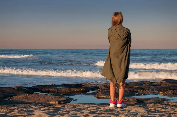 Frumoasă femeie tânără pe plajă, uitându-se la valuri — Fotografie, imagine de stoc