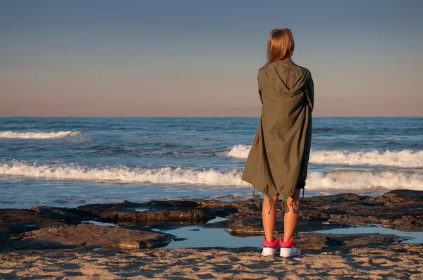 Hermosa joven en la playa, mirando las olas — Foto de Stock