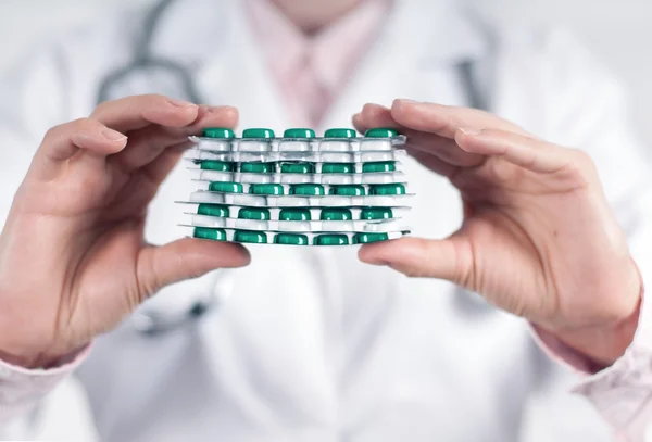 A mão do médico segurando uma pilha de muitos comprimidos diferentes — Fotografia de Stock