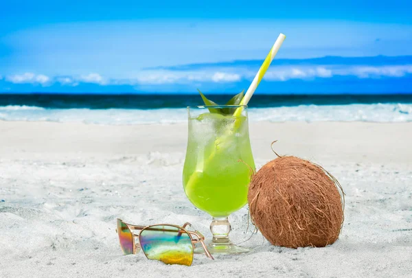 Cóctel refrescante y coco en la mesa de playa . — Foto de Stock