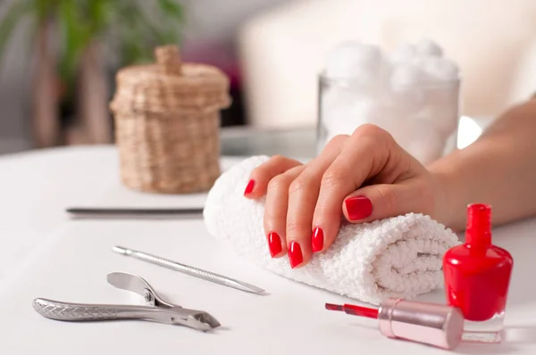 Schöne Maniküre, Frauenhand mit roter Maniküre am Nagel — Stockfoto