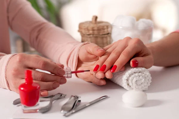 Concepto de manicura. Hermosa mano de mujer wiith uñas rojas en el spa . —  Fotos de Stock