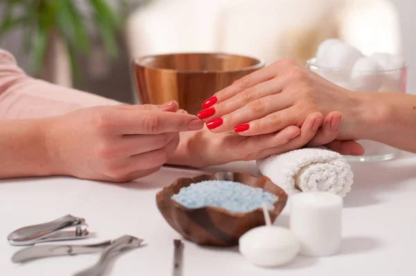 Concepto de manicura. Hermosa mano de mujer wiith uñas rojas en el spa . — Foto de Stock