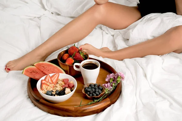 Γυναίκα τρώει πρωινό στο κρεβάτι. — Φωτογραφία Αρχείου