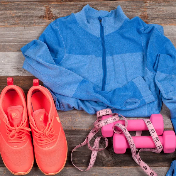 Traje de gimnasio: ropa de entrenamiento, zapatillas de deporte, mancuernas y medidas . — Foto de Stock