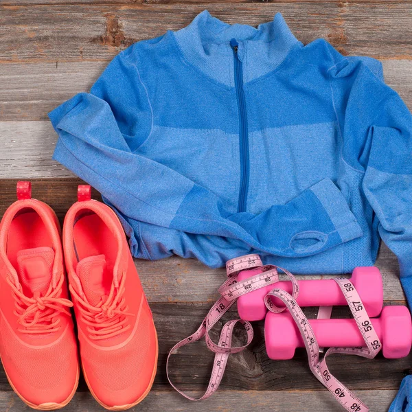 Traje de gimnasio: ropa de entrenamiento, zapatillas de deporte, mancuernas y medidas . — Foto de Stock