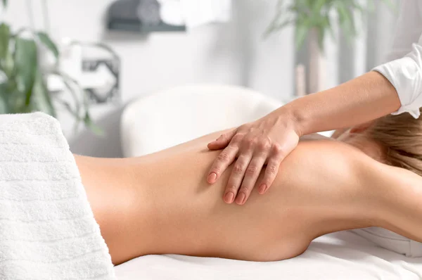 Mujer teniendo masaje de cuerpo en el salón de spa . — Foto de Stock