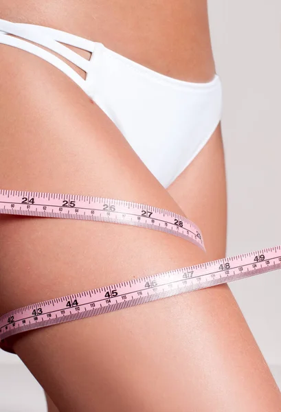 Conceito de dieta, mulher medindo a perna com uma fita métrica — Fotografia de Stock