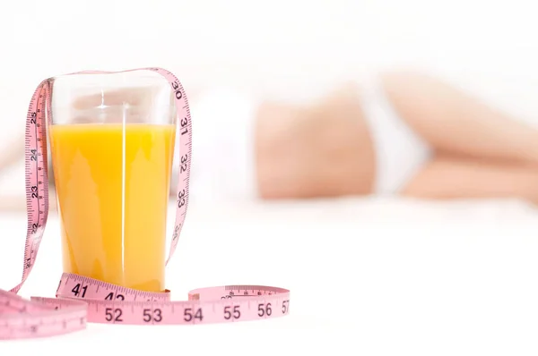 Стакан апельсинового сока и измерительная лента — стоковое фото