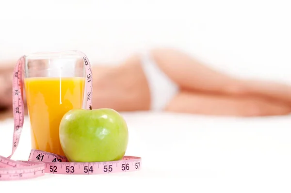 Copo de suco de laranja com maçã verde e fita métrica — Fotografia de Stock