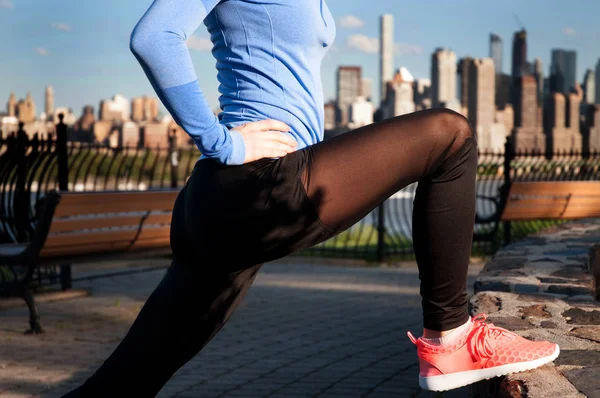 Женщина растягивается перед фитнесом с видом на парк Манхэттен — стоковое фото