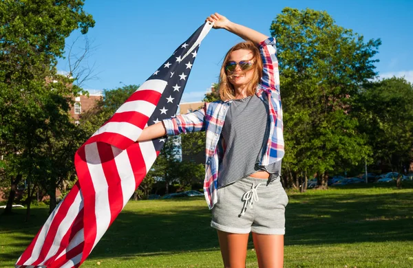 Jovem mulher patriota feliz segurando bandeira dos Estados Unidos — Fotografia de Stock