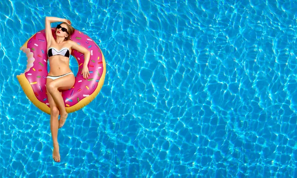 Bikini yüzme havuzunda şişme şişme kadın. 