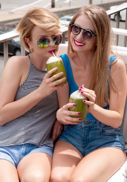 Deux jeunes femmes s'amusent et boivent un cocktail le jour d'été — Photo