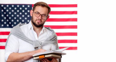 Amerika Birleşik Devletleri bayrağı arka plan üzerinde gülümseyen genç adam. 