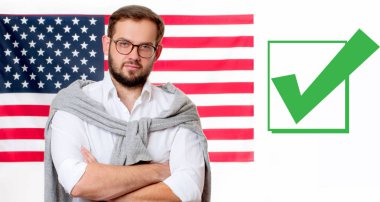 Amerika Birleşik Devletleri bayrağı arka plan üzerinde gülümseyen genç adam. 