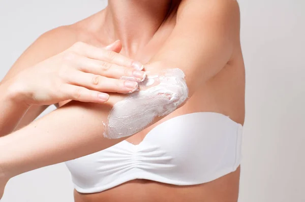 Bellezza e cura del corpo. Donna che applica la crema sul gomito . — Foto Stock