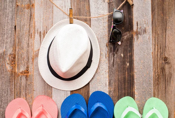 Sombrero, gafas de sol y sandalias chanclas sobre fondo de madera — Foto de Stock