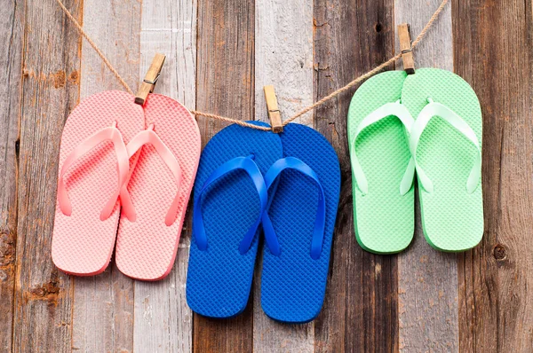 Růžové, modré a zelené pantofle sandále na pozadí — Stock fotografie