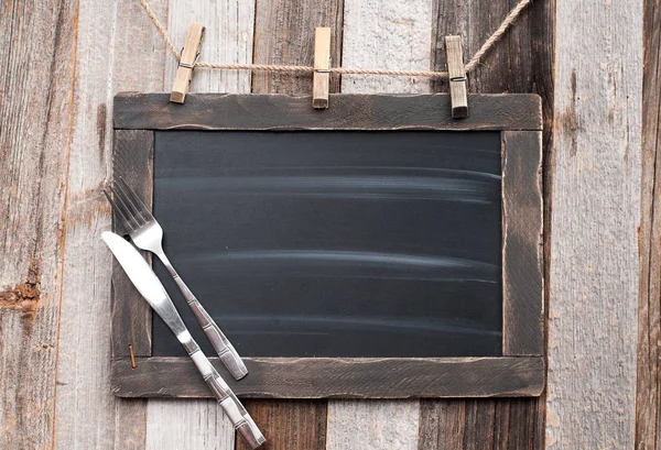 Çatal ve bıçak ahşap arka plan üzerinde menü yazı tahtası 