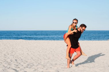 Mutlu genç neşeli çift yaz tatil tatil sırasında birlikte tropikal plaj.